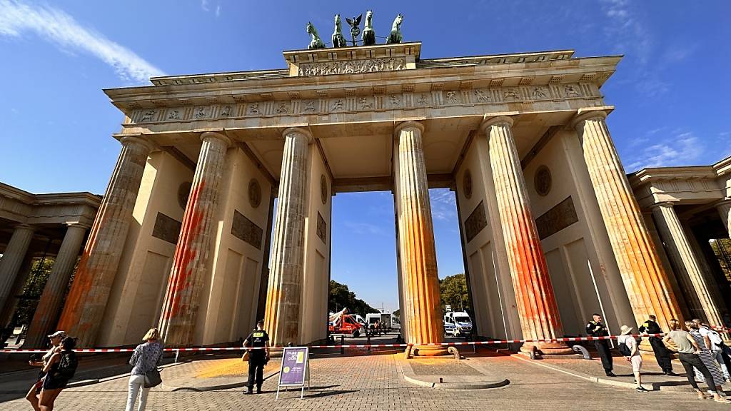 Mitglieder der Klimaschutzgruppe Letzte Generation haben das Brandenburger Tor in Berlin mit oranger Farbe angesprüht. Foto: Paul Zinken/dpa