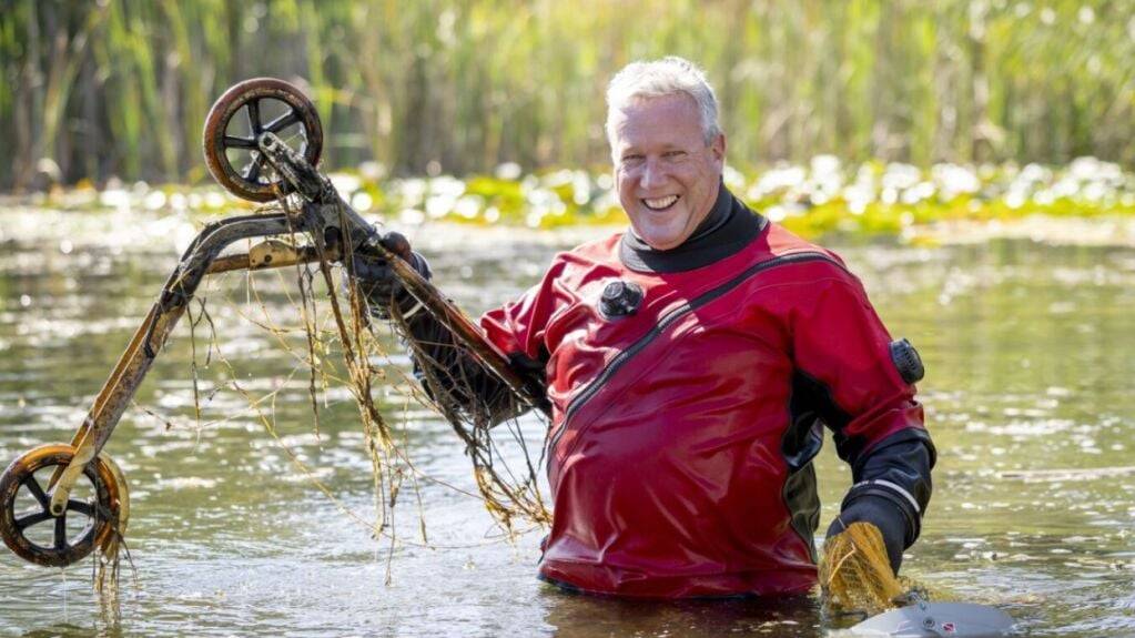 Ein Taucher fischt ein Kickboard anlässlich des nationalen Clean-Up-Days aus einem Teich.