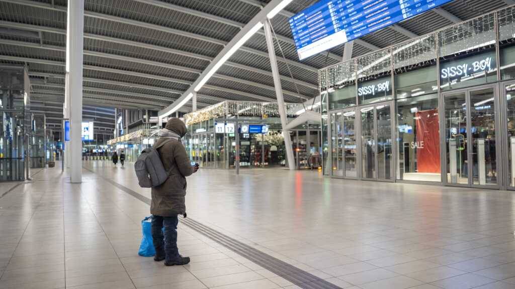 Eine Person steht vor einer Anzeigetafel in der leeren Halle des Hauptbahnhofs Utrecht. Die Züge der Niederländischen Eisenbahnen (NS) verkehren derzeit aufgrund von Winterwetter und einer IT-Störung nicht. Foto: Jeroen Jumelet/ANP/dpa