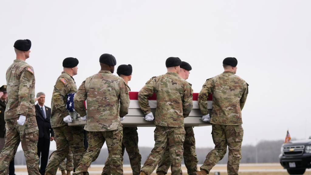 dpatopbilder - US-Soldaten tragen eine mit einer US-Flagge bedeckte Transportkiste mit den sterblichen Überresten eines US-Soldaten. Foto: Mark Schiefelbein/AP/dpa