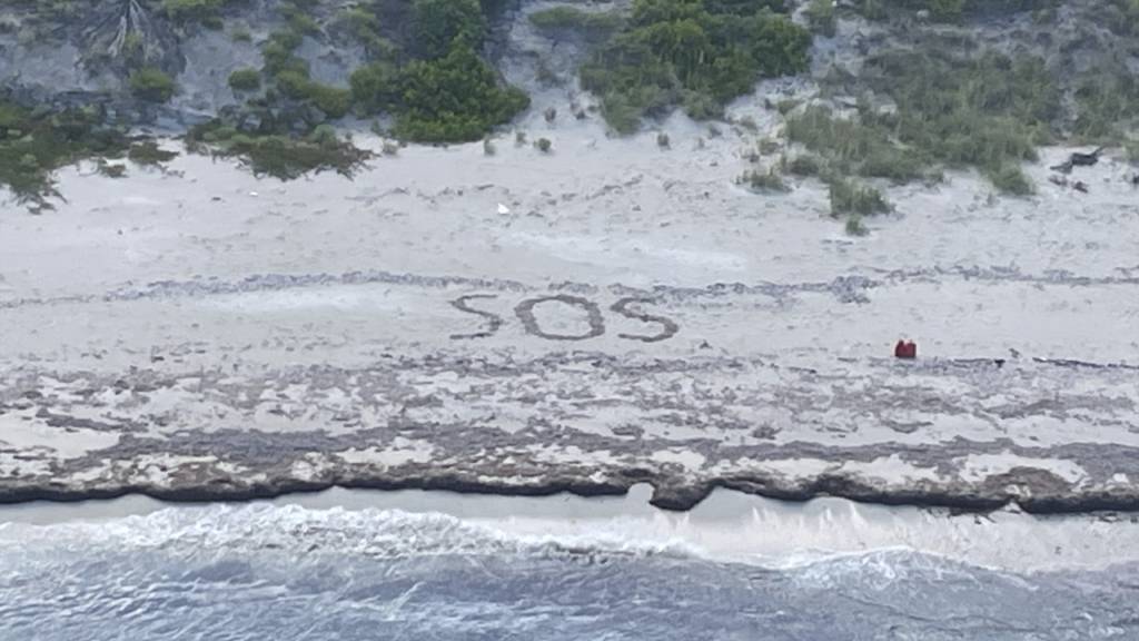 HANDOUT - «SOS»: Ein 64-jähriger Mann war drei Tage lang auf einer Insel in den Bahamas gestrandet. Foto: Uncredited/U.S. Coast Guard/AP/dpa - ACHTUNG: Nur zur redaktionellen Verwendung und nur mit vollständiger Nennung des vorstehenden Credits