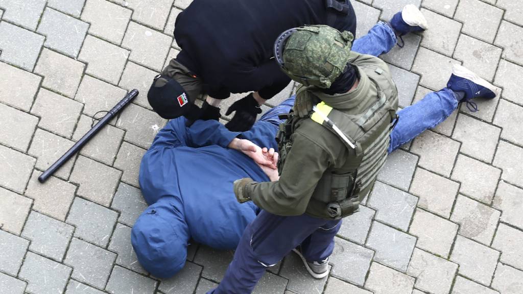 Polizisten nehmen während eines Protests der Opposition in Minsk einen am Boden liegenden Mann fest. Foto: ---/AP/dpa