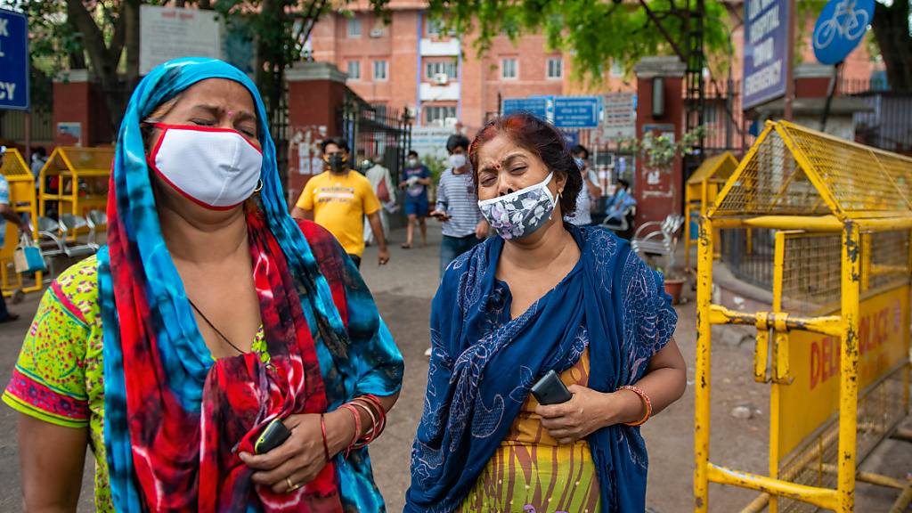 Zwei Frauen betrauern in Neu Delhi den Tod eines Angehörigen. Foto: Pradeep Gaur/SOPA Images via ZUMA Wire/dpa