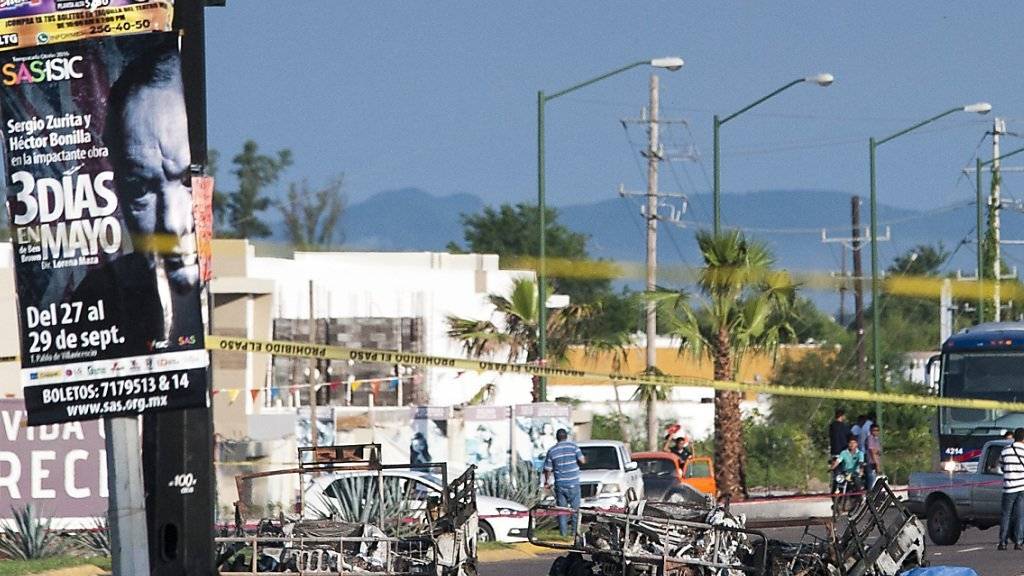 Polizisten untersuchen den Tatort nach einem Überfall auf einen Militärkonvoi in Cuilacan in West-Mexiko. Dabei wurden fünf Soldaten getötet. Die Behörden vermuten, dass ein Drogenkartell hinter dem Angriff steckt.