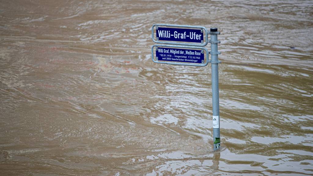 Die Saar ist über die Ufer getreten. Heftiger Dauerregen hat im Saarland vielfache Überflutungen und Erdrutsche verursacht. Foto: Laszlo Pinter/dpa