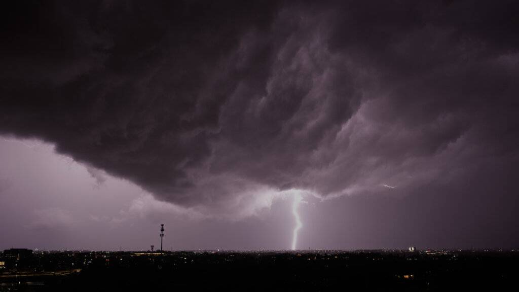 ARCHIV - Blitze zucken in Lenexa, Kansas, während in der Ferne ein Gewitter vorbeizieht. Foto: Charlie Riedel/AP/dpa