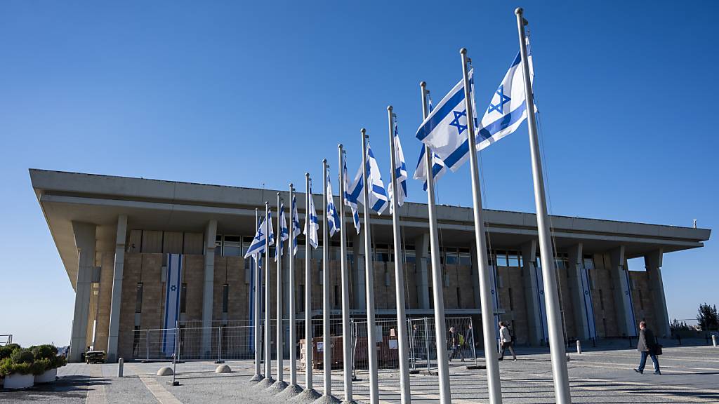 ARCHIV - Israelische Fahnen wehen vor der Knesset, dem Einkammerparlament des Staates Israel. Foto: Christophe Gateau/dpa