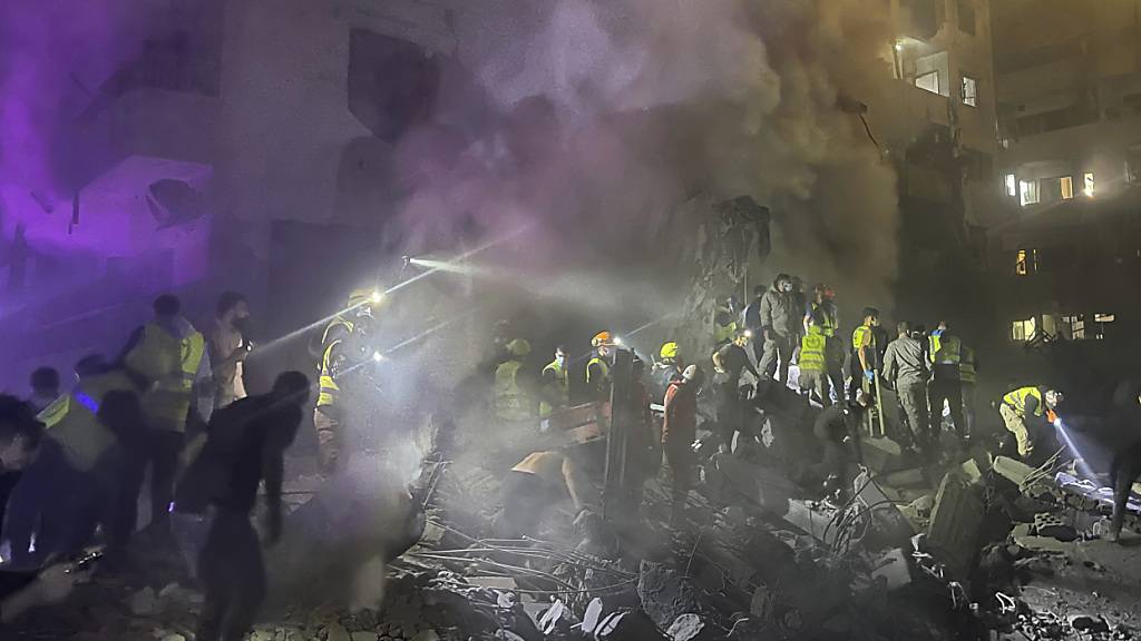 Rettungskräfte und Menschen suchen nach Opfern am Ort eines israelischen Luftangriffs in Beirut, Libanon. Foto: Bilal Hussein/AP/dpa