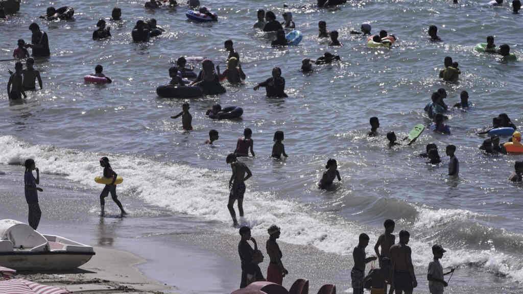 ARCHIV - Menschen verbringen Zeit am Strand in der Nähe der Stadt Alexandria. Foto: Amr Nabil/AP/dpa
