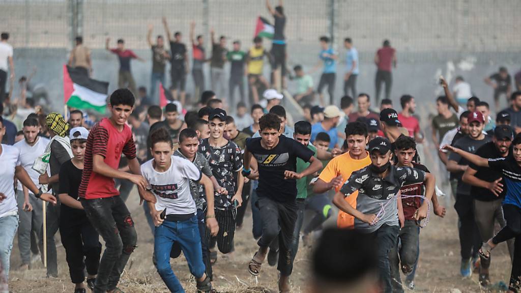 Palästinensische Demonstranten stoßen mit israelischen Sicherheitskräften zusammen, nachdem sie am Grenzzaun zu Israel östlich von Gaza-Stadt gegen die israelische Belagerung des palästinensischen Streifens protestiert haben. Foto: Mohammed Talatene/dpa
