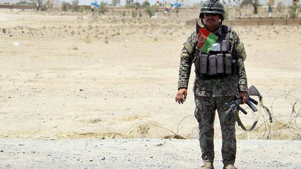Ein afghanischer Soldat bewacht die Strasse auf dem Weg zum Anschlagsort.