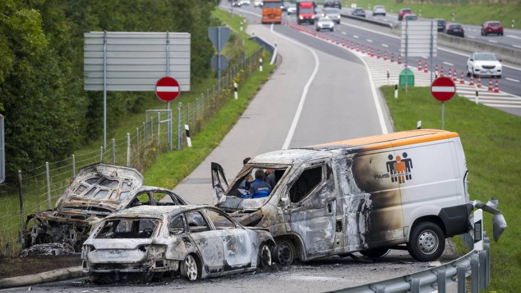 Die Täter hinterliessen bei ihrem Raubüberfall ein Spur der Verwüstung: drei ausgebrannte Fahrzeuge bei der Autobahnausfahrt in La Sarraz VD. (Archivbild)