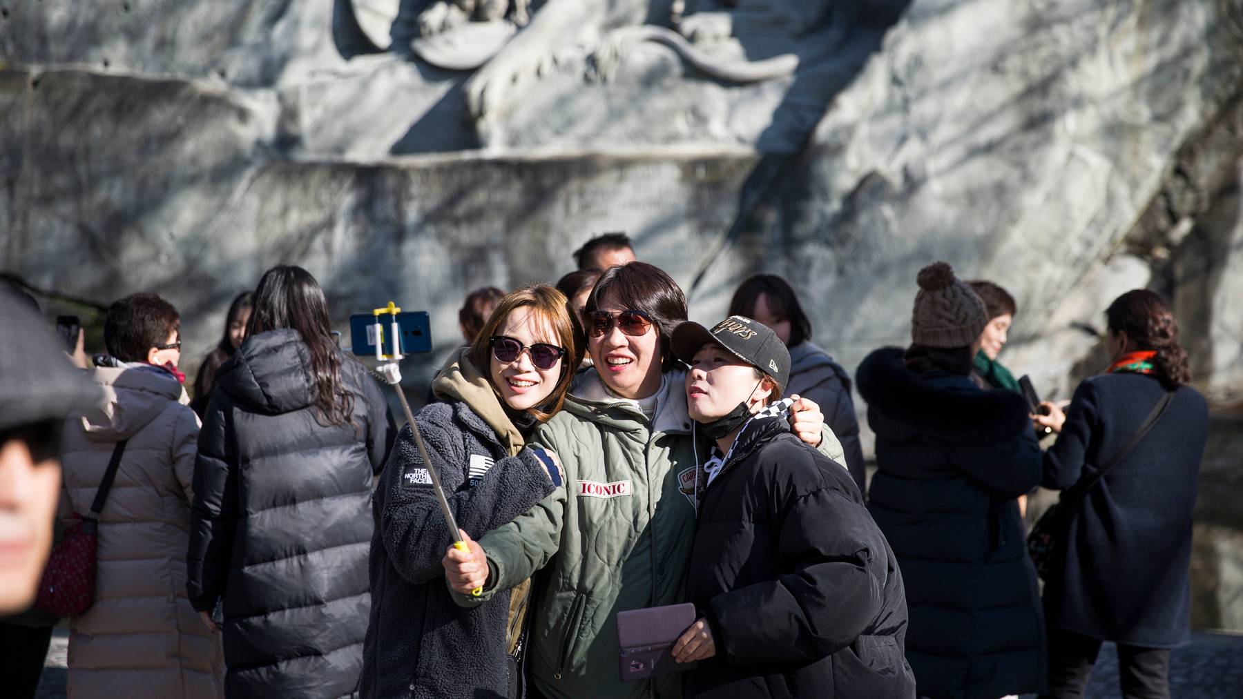 Eine Gruppe asiatischer Touristen vor dem Löwendenkmal in Luzern.