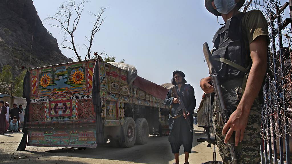 ARCHIV - Ein pakistanischer Soldat (r) und Kämpfer der Taliban stehen Wache an einem Grenzübergang zwischen Pakistan und Afghanistan in der Provinz Khyber Pakhtunkhwa auf den jeweiligen Seiten der Länder. Foto: -/AP/dpa