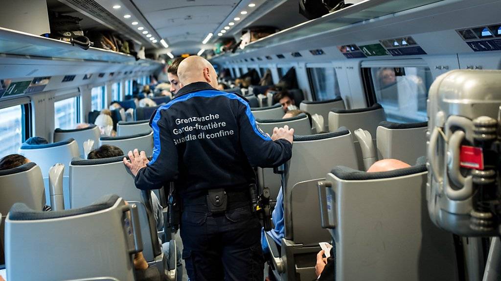 Mitarbeiter der Grenzwache kontrollieren in einem Zug Passagiere. (Archivbild)