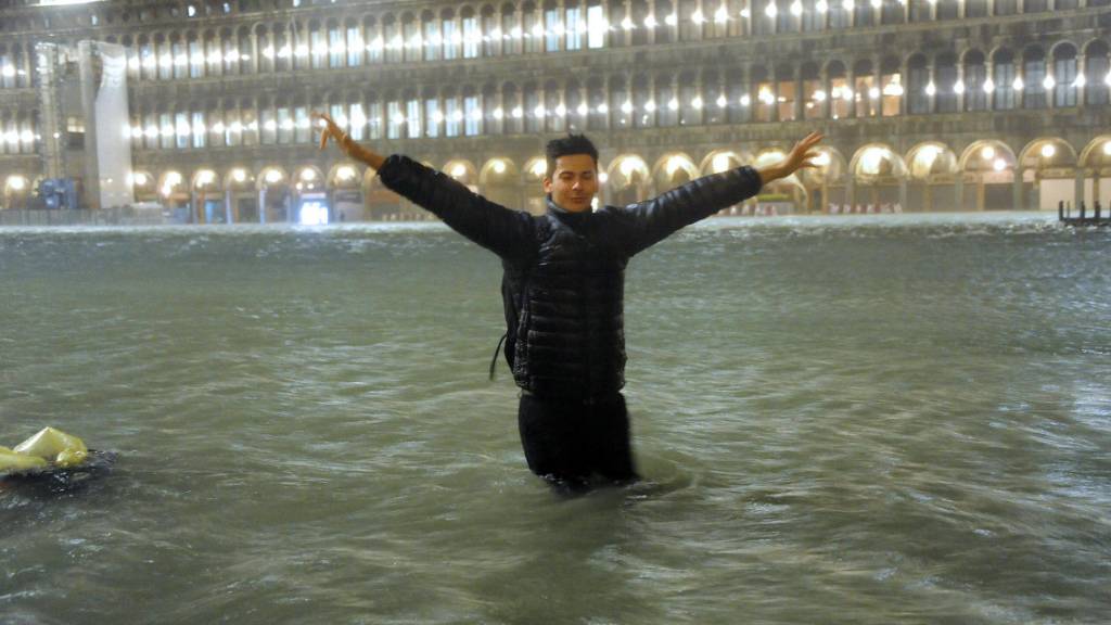 Ein Mann steht auf dem überfluteten Markusplatz in Venedig. (Archivbild)