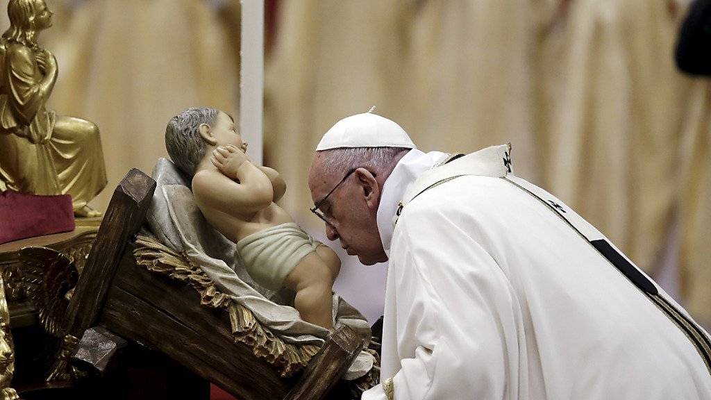 Christmesse im Petersdom: Papst Franziskus küsst bei eine Statue des Jesuskinds.