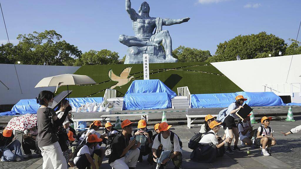 Besucher des Friedensparks ducken sich, als in Nagasaki im Westen Japans Erdbebenalarm ausgerufen wurde. Foto: Uncredited/Kyodo News/AP