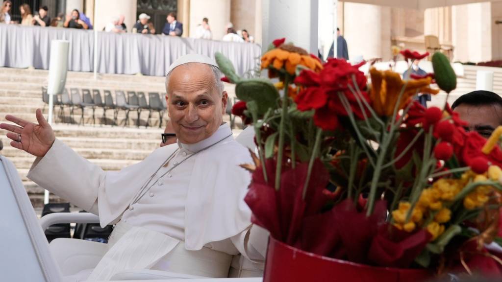 dpatopbilder - Papst Leo XIV. erhält Blumen, als er am am Ende der Generalaudienz auf dem Petersplatz im Vatikan den Platz verlässt. Foto: Gregorio Borgia/AP/dpa
