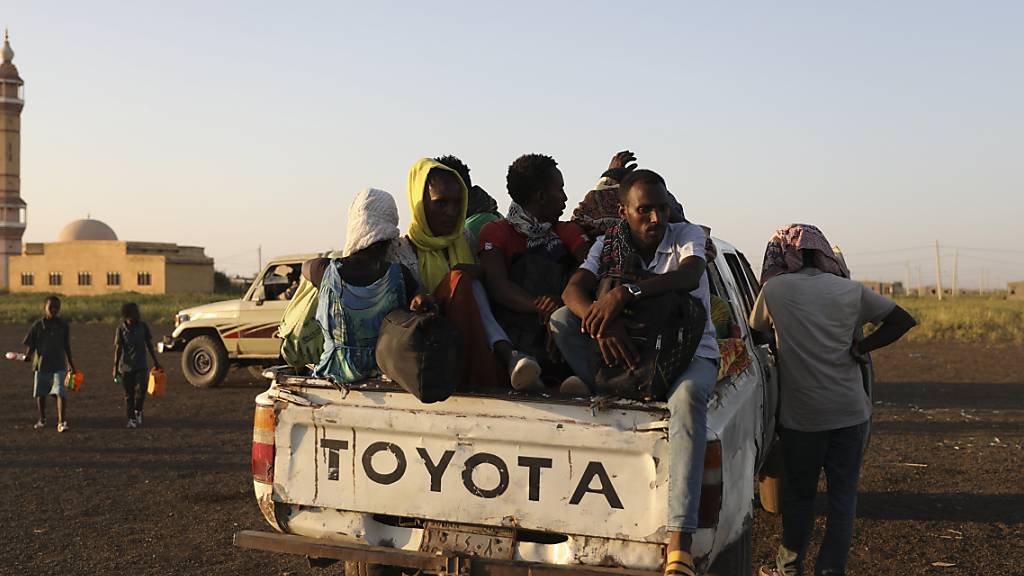 Äthiopische Flüchtlinge sitzen auf der Ladefläche eines Pick-ups. Nach Angaben des UN-Flüchtlingshilfswerks hat der wachsende Konflikt in Äthiopien dazu geführt, dass Tausende aus der Region Tigray in den Sudan geflohen sind. Äthiopiens Militär erhält in seinem Kampf gegen die Volksbefreiungsfront von Tigray (TPLF) nach deren Angaben auch Unterstützung aus Eritrea sowie einem nicht näher bezeichneten Staat außerhalb Afrikas. Foto: Marwan Ali/AP/dpa