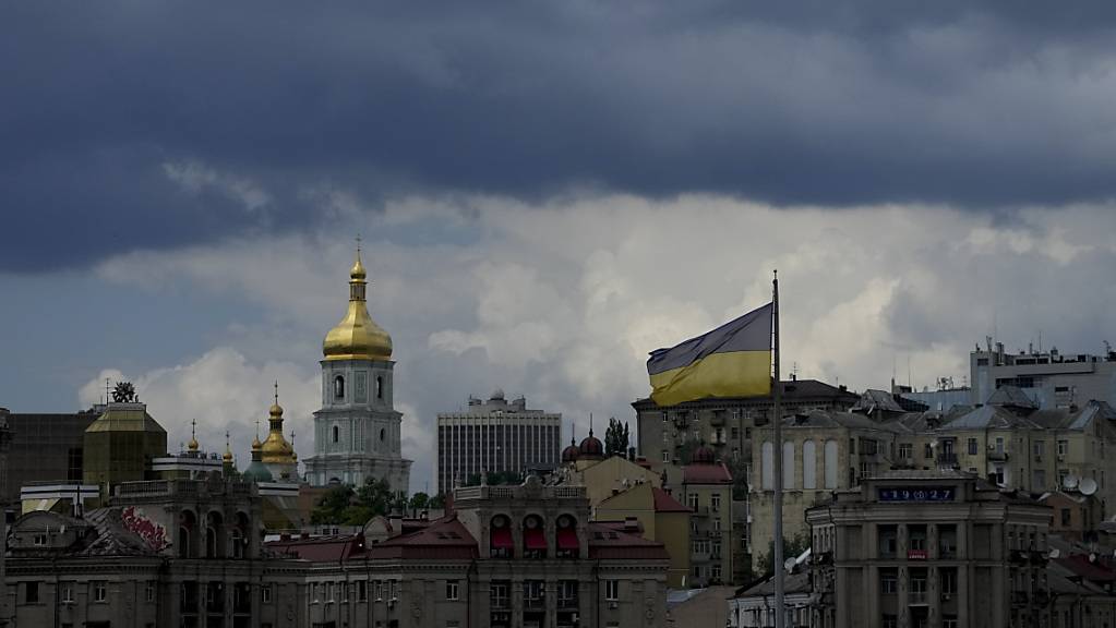 Eine ukrainische Flagge weht vor Gebäuden in Kiew.
