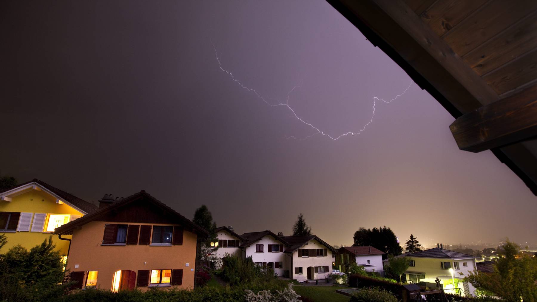 Ein Blitz erstrahlt am Dienstag, 25. Mai 2010, am naechtlichen Himmel ueber einer Wohnsiedlung in Igis im Churer Rheintal. Nach dem ersten Hitzetag in diesem Jahr mit Hoechtstemperaturen von ueber 30 Grad zieht am spaeten Dienstagabend ein kraeftiges Gewitter ueber das Churer Rheintal hinweg.