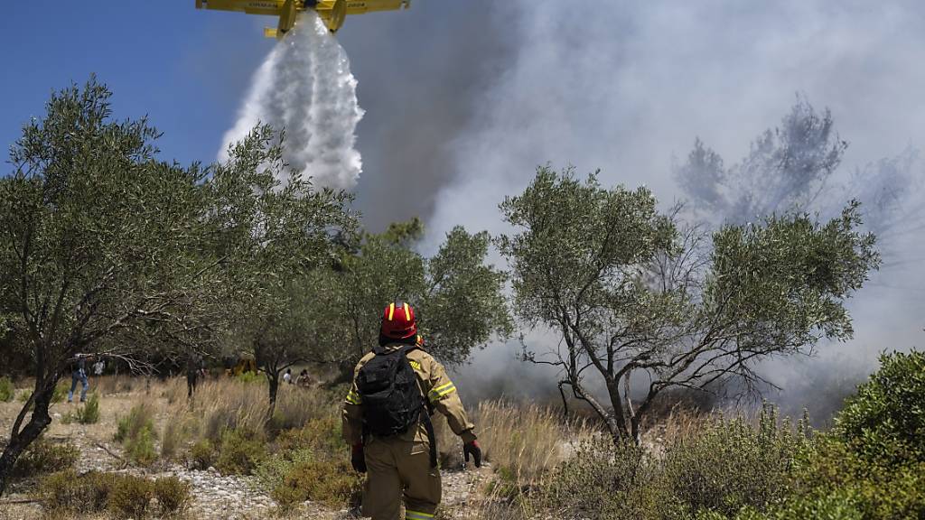 Ein Flugzeug wirft Wasser über einem Waldbrand beim Dorf Vati ab. Auf der Insel Euböa ist bei einem Einsatz ein Löschflugzeug abgestürzt. Foto: Petros Giannakouris/AP/dpa