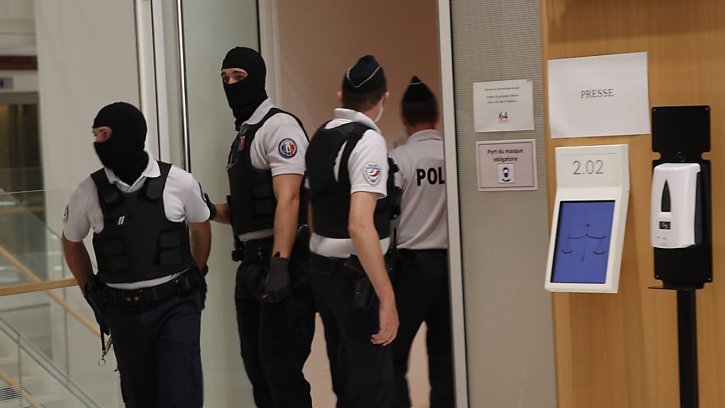 Polizisten stehen Wache vor dem Gerichtssaal in dem der Prozess gegen den mutmaßlichen Helfer der Anschläge auf die Redaktion «Charlie Hebdo» stattfindet. Der Prozess sollte bereits am 4. Mai beginnen und wurde wegen des Coronavirus auf die Zeitspanne vom 2. September bis 10. November verschoben. Foto: Francois Mori/AP/dpa