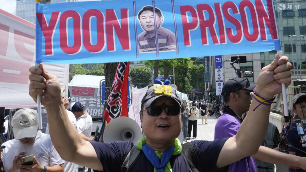 Ein Demonstrant gegen den ehemaligen südkoreanischen Präsidenten Yoon entrollt ein Transparent während einer Kundgebung. Foto: Ahn Young-joon/AP/dpa