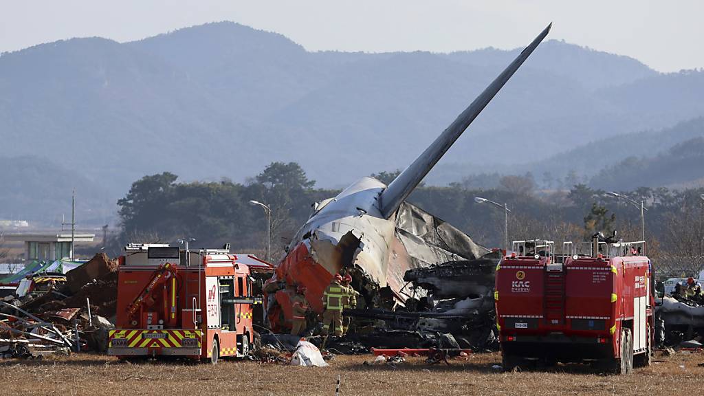 dpatopbilder - Feuerwehrleute und Rettungskräfte arbeiten am internationalen Flughafen von Muan. Bei der Landung am internationalen Flughafen von Muan in Südkorea ist ein Passagierflugzeug verunglückt. Foto: Cho Nam-soo/Yonhap/AP/dpa