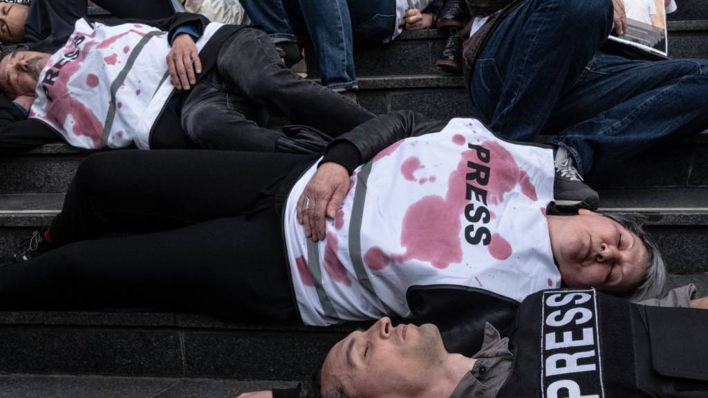ARCHIV - Menschen nehmen in Frankreich mit symbolisch rot beschmierten Presse-Westen an einem Protest gegen Gewalt an Journalisten teil. Foto: Sadak Souici/ZUMA Press Wire/dpa/Archivbild