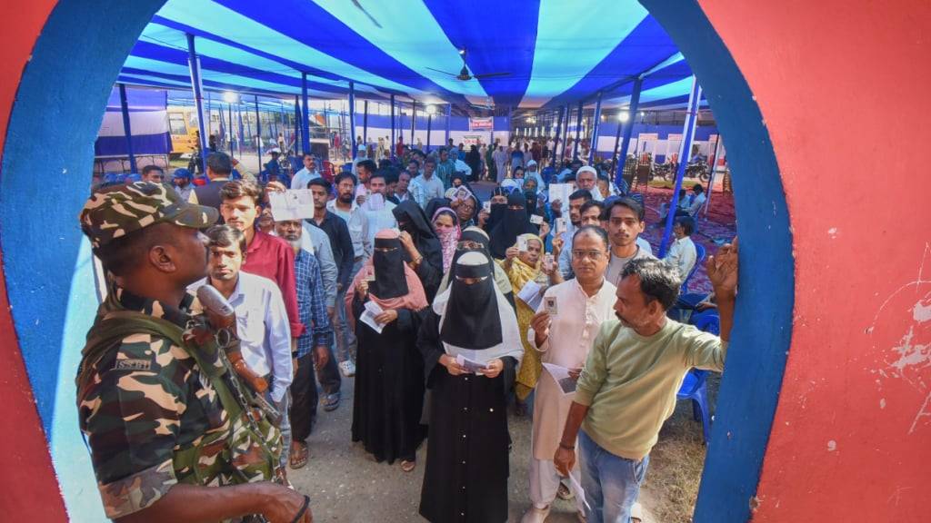 ARCHIV - Menschen stehen in einer Schlange, um ihre Stimme für die Wahlen in Bihar abzugeben. Foto: Uncredited/AP/dpa