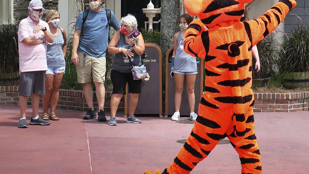 Willkommen mit Schutzmaske: Tigger begrüsst Gäste beu der Wiedereröffnung des Magic Kingdom in Walt Disney World in Lake Buena Vista, Florida.