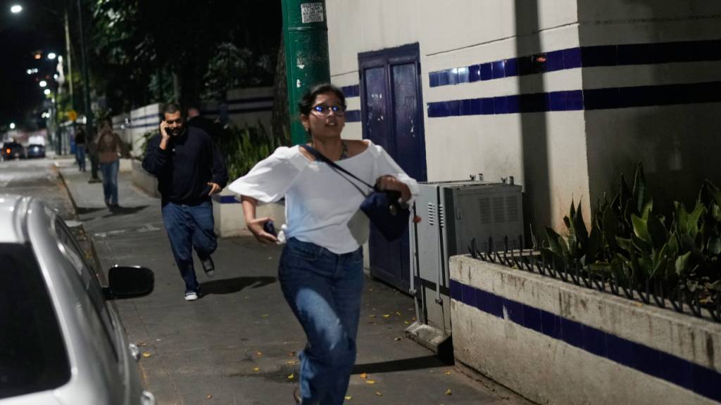 Fliehende Menschen in Caracas. Foto: Matias Delacroix/AP/dpa