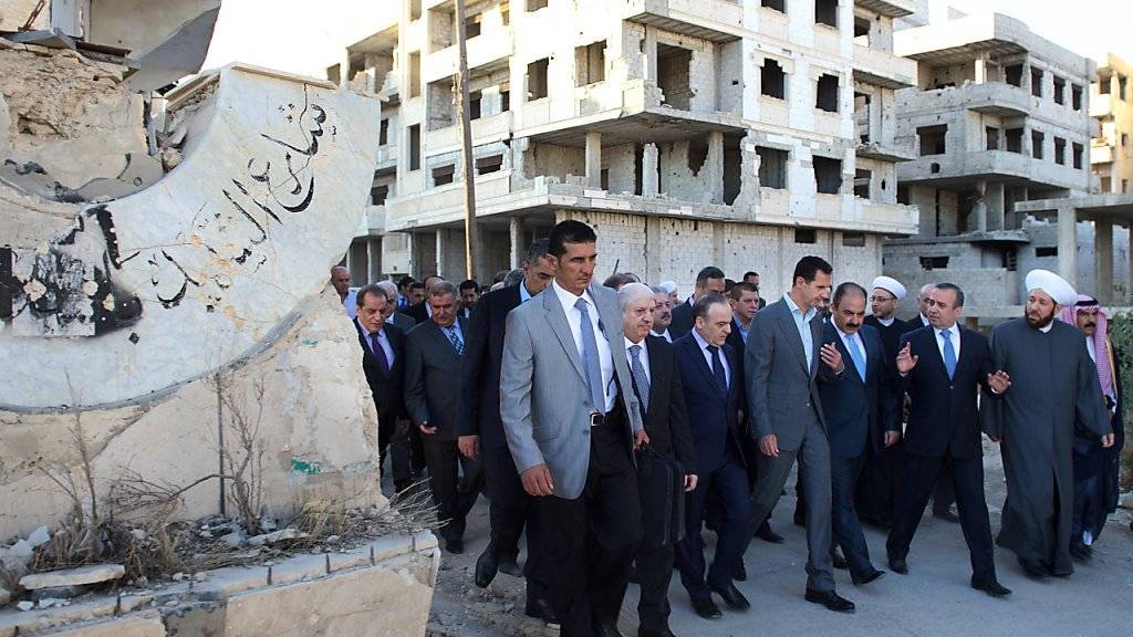 Der syrische Präsident Assad (Mitte, im grauen Anzug) mit seiner Delegation in Daraja. Er kündigte kurz vor der geplanten Waffenruhe die Rückeroberung des gesamten Staatsgebietes an.