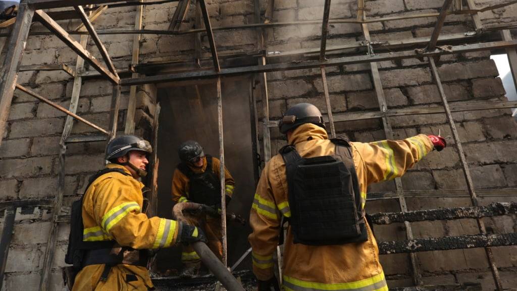 Rettungskräfte löschen ein Feuer in einem Geschäft, das durch einen russischen Raketenangriff zerstört wurde. Foto: Kateryna Klochko/AP/dpa
