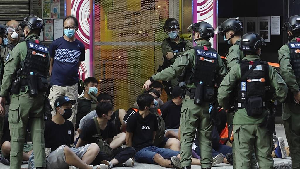 Polizisten nehmen Demonstranten (M) fest. Nach der umstrittenen Verschiebung der Wahl um ein Jahr hatte die Opposition in der chinesischen Sonderverwaltungszone für Sonntag zu Protesten aufgerufen. Foto: Vincent Yu/AP/dpa