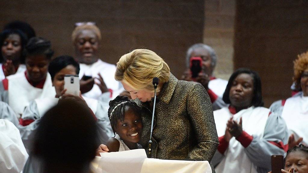 US-Präsidentschaftskandidatin Hillary Clinton umarmt in der Unruhestadt Charlotte die neunjährige Zianna Oliphant, die vergangene Woche von ihren Ängsten aufgrund ihrer Hautfarbe berichtete.