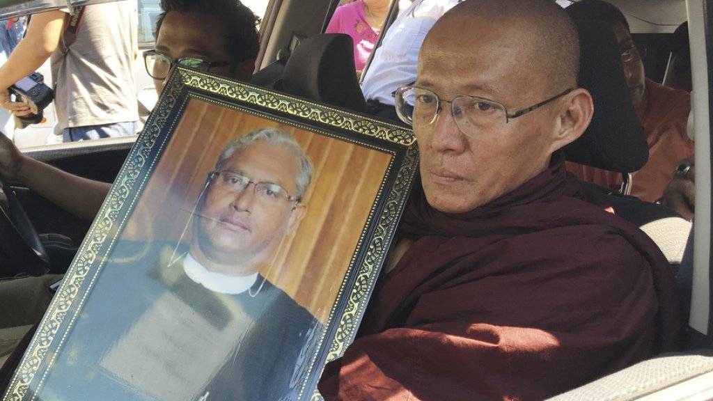 Ein buddhistischer Mönch am Montag in Yangon mit einem Bild des Ermordeten.