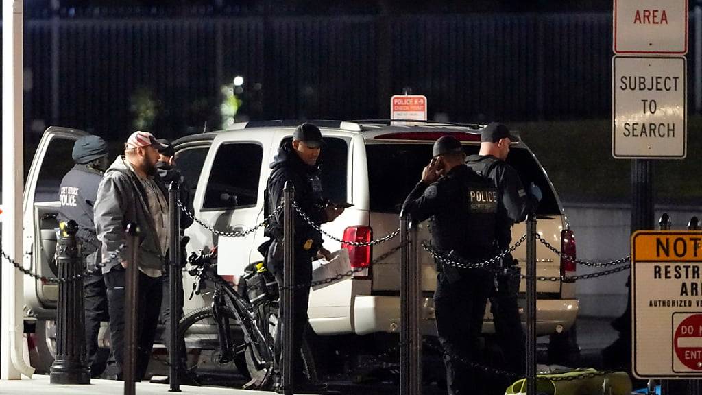 Die Polizei des Secret Service untersucht ein Fahrzeug, das gegen eine Sicherheitsschranke am Eingang des Weißen Hauses gefahren ist. Foto: Mark Schiefelbein/AP/dpa