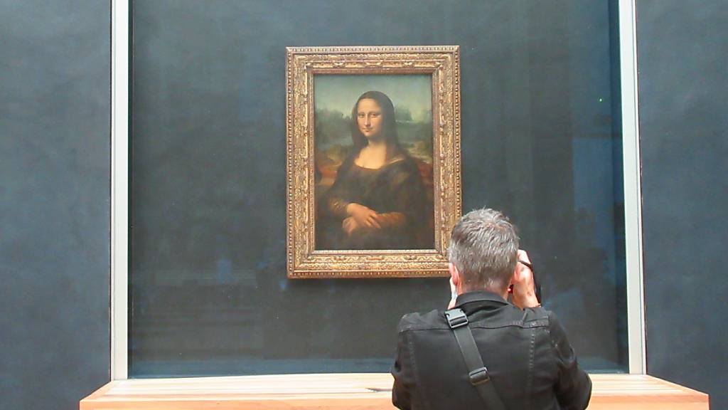 Ein Besucher des Louvre fotografiert die «Mona Lisa» von Leonardo da Vinci. Foto: Sabine Glaubitz/dpa