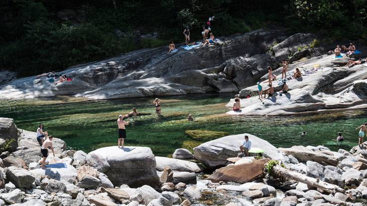 Menschen geniessen sonniges Wetter am Verzascafluss im Verzascatal in Lavertezzo.