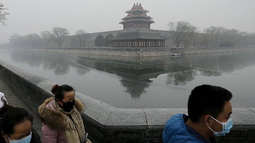 Maskierte Menschen bei der Verbotenen Stadt in Peking: Nach drei Tagen hat die Stadt die höchste Smog-Warnstufe aufgehoben. (Archivbild)