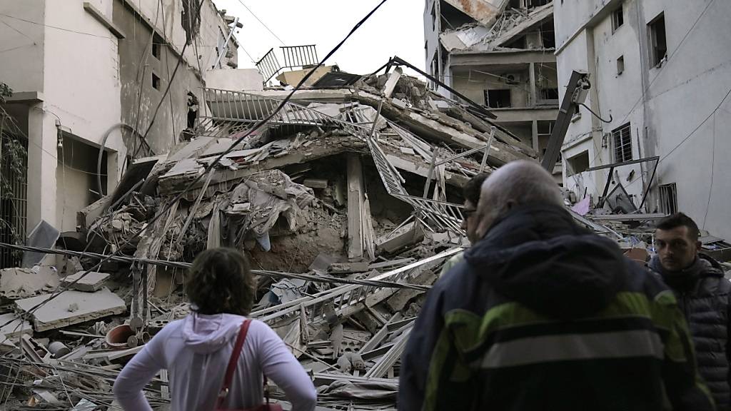 Anwohner sichten ihr zerstörtes Gebäude, das bei einem israelischen Luftangriff in Dahieh, einem südlichen Vorort der libanesischen Hauptstadt, getroffen wurde. Foto: Hussein Malla/AP/dpa