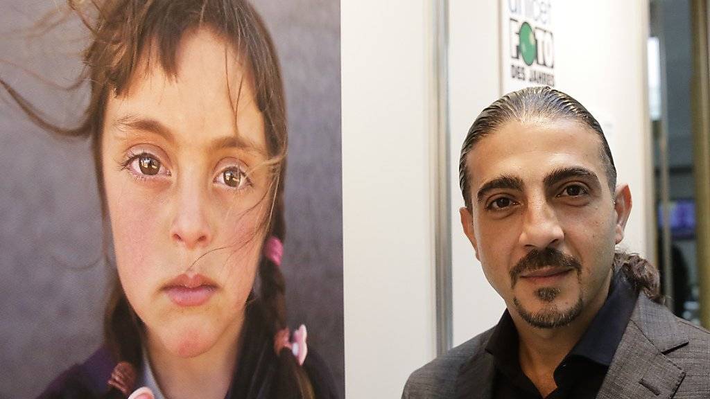 Fotograf Muhammend Muheisen neben seinem Bild, das zum Unicef-«Foto des Jahres» gekürt wurde.