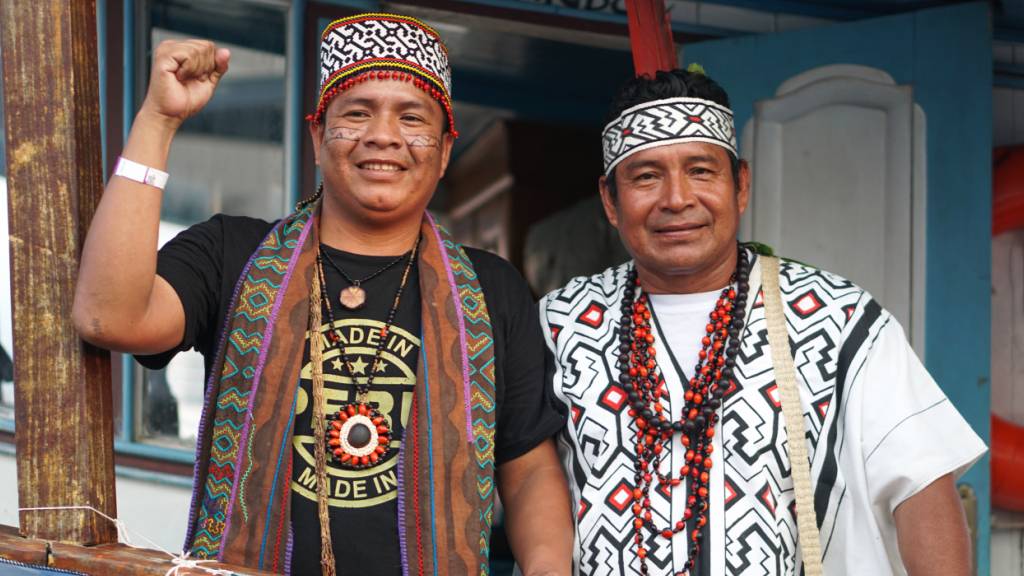 Indigene Aktivisten stehen an Bord der «Amazon Flotilla», mit der sie über 3000 Kilometer auf dem Amazonas-Fluss zur Weltklimakonferenz nach Brasilien gefahren sind. Foto: Larissa Schwedes/dpa