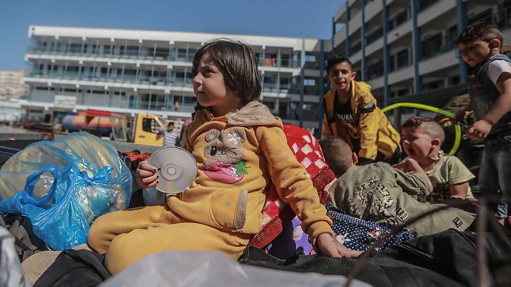 Palästinenser sitzen mit ihren Habseligkeiten vor einer UN-Schule, in der sie Schutz suchen. Sie mussten während der israelischen Luftangriffe aus ihren Häusern fliehen inmitten des eskalierenden Aufflammens der israelisch-palästinensischen Gewalt.