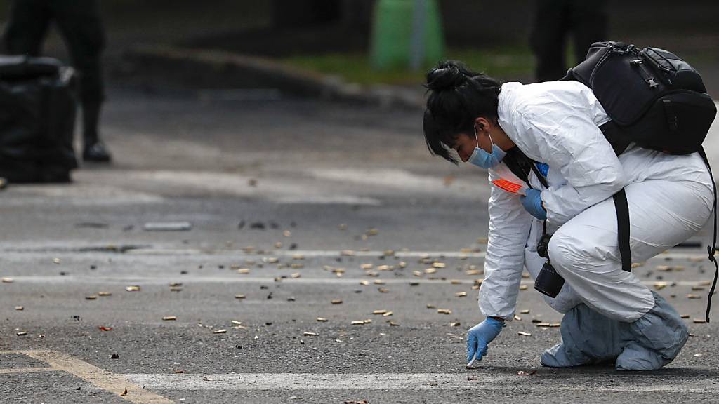 ARCHIV - Eine Mitarbeiterin der Forensik kniet neben zahlreichen Patronen nach einem Attentat gegen den Polizei-Chef von Mexiko-Stadt. Foto: Rebecca Blackwell/AP/dpa
