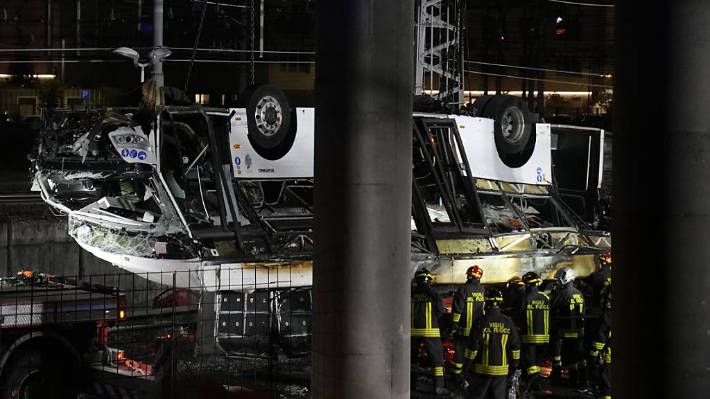 Italienische Feuerwehrleute arbeiten nach einem Busunglück an der Unfallstelle. Foto: Antonio Calanni/AP