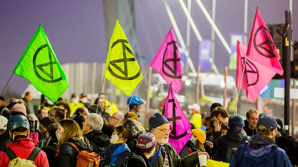 ARCHIV - Menschen mit Fahnen der Umweltschutzbewegung Extinction Rebellion protestieren am Rande der UN-Klimakonferenz COP26 in Glasgow für besseren Klimaschutz. Foto: Christoph Soeder/dpa